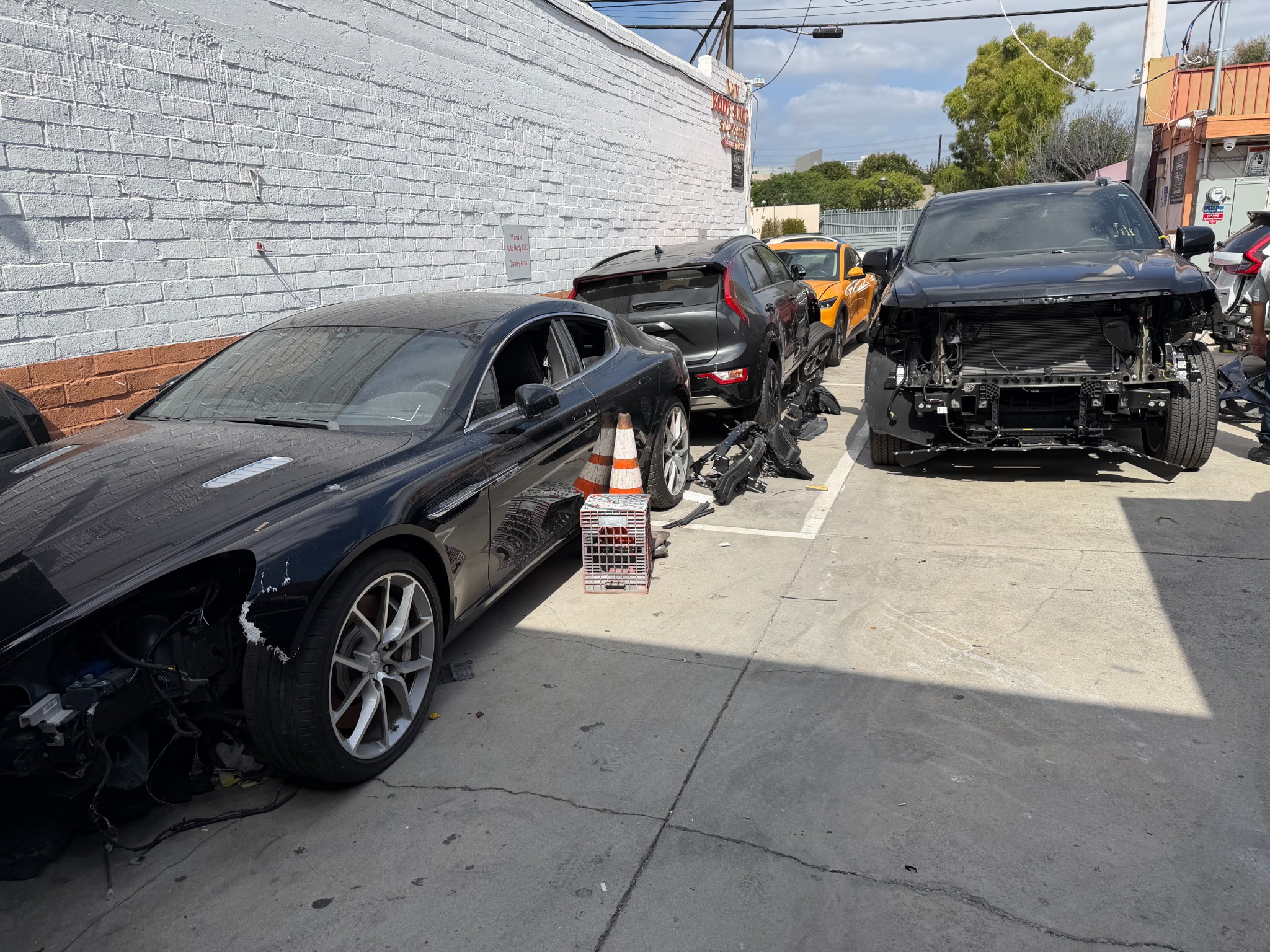 Vehicles undergoing collision repair at V and V Auto Body in Los Angeles